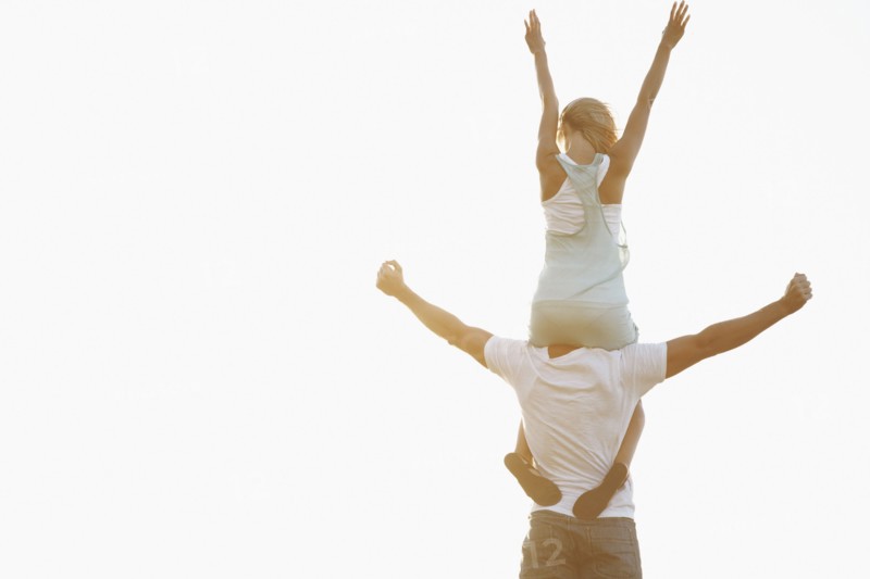 Man carrying woman on his shoulders. Photographe : momentimages