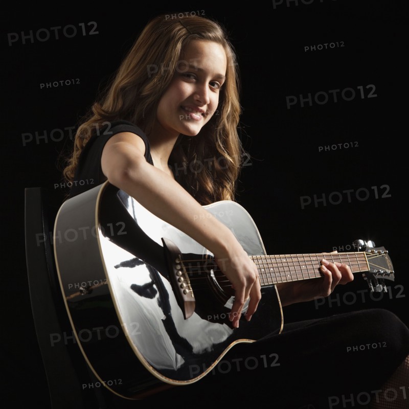 Young woman playing guitar. Photographe : Mike Kemp