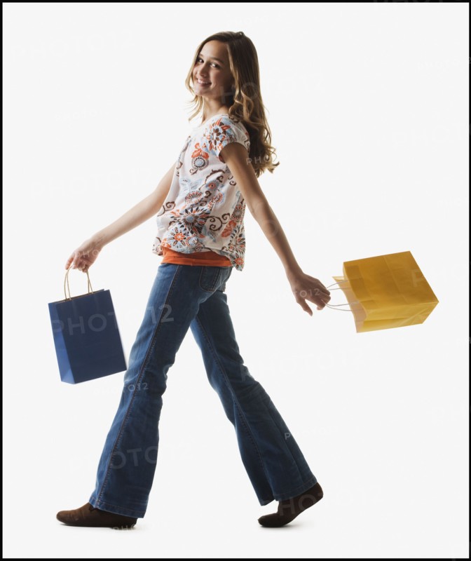 Young girl holding shopping bags. Photographe : Mike Kemp
