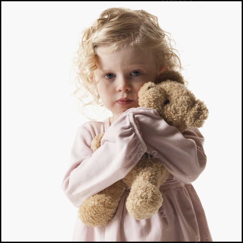 Young girl holding teddy bear. Photographe : Mike Kemp
