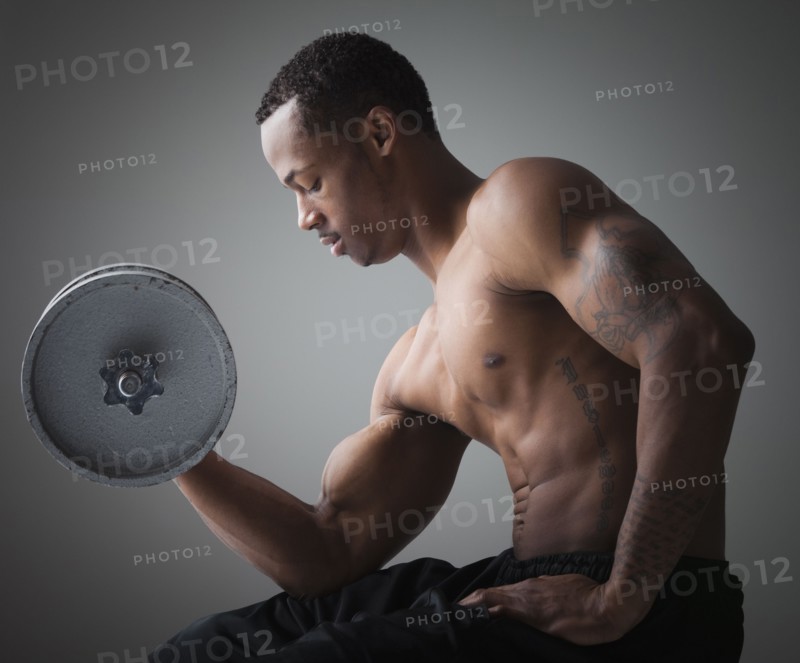 Muscular man lifting a dumbbell. Photographe : Mike Kemp