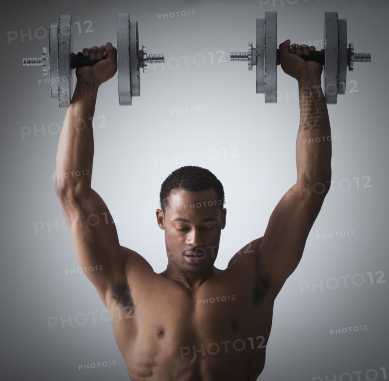 Muscular man lifting dumbbells. Photographe : Mike Kemp
