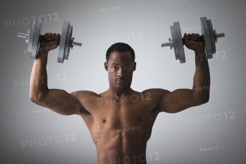 Muscular man lifting dumbbells. Photographe : Mike Kemp