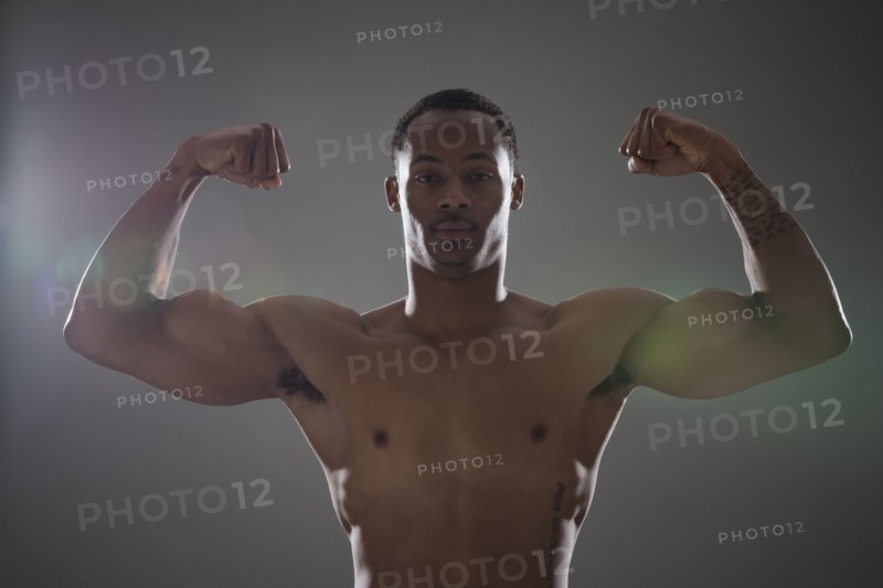 Physically fit man flexing his triceps. Photographe : Mike Kemp