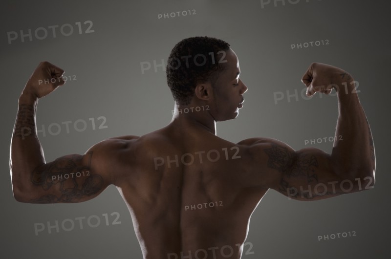 Physically fit man flexing his triceps. Photographe : Mike Kemp