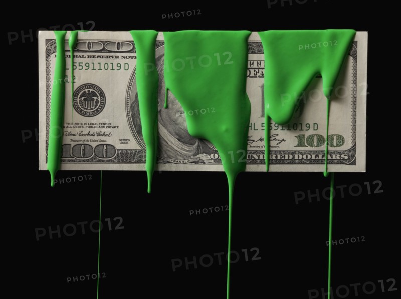 American currency covered in green paint. Photographe : Mike Kemp