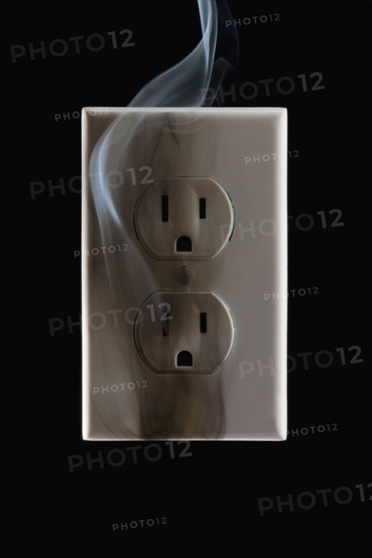 Smoke emanating from an electrical outlet. Photographe : Mike Kemp