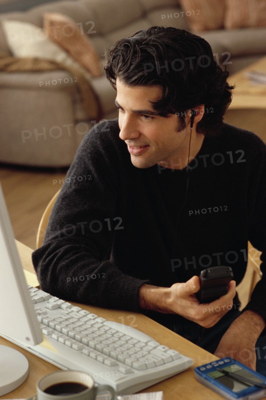 Man looking at home computer. Photographe : Rob Lewine