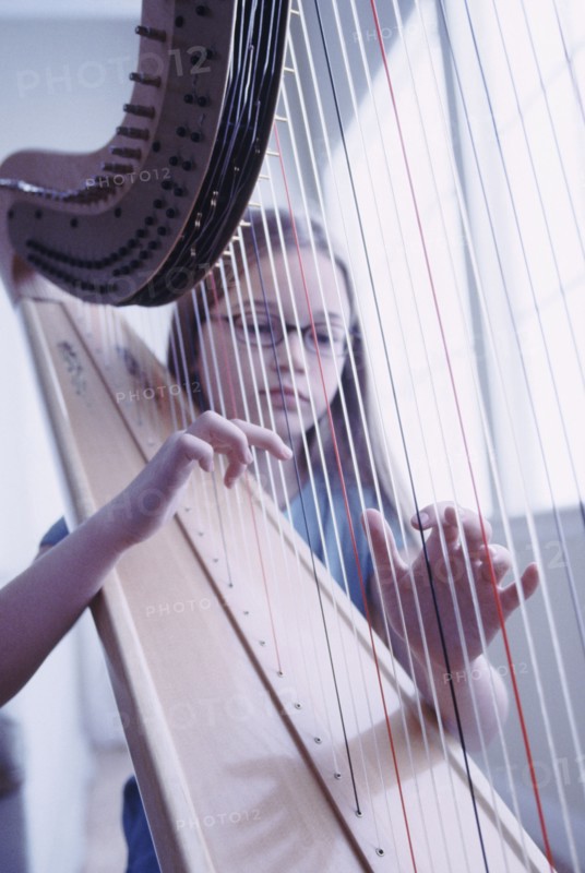 Young girl playing the harp. Photographe : Rob Lewine