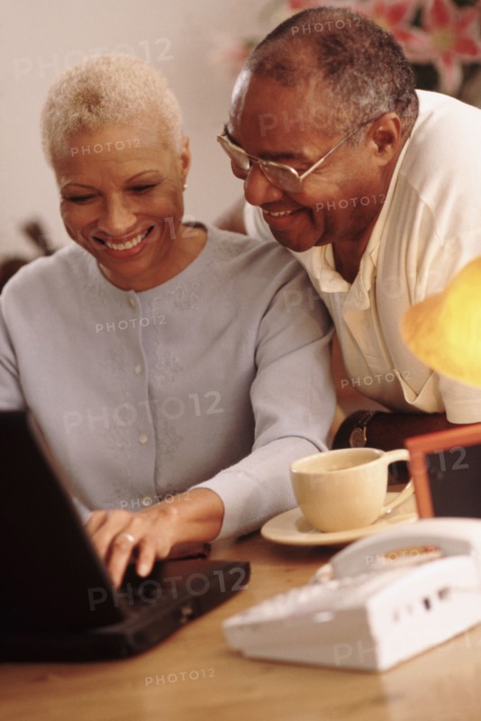 Couple looking at a laptop together. Photographe : Rob Lewine