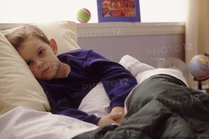Young boy sick in bed. Photographe : Rob Lewine