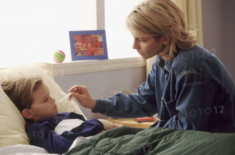 Mother checking son's temperature. Photographe : Rob Lewine