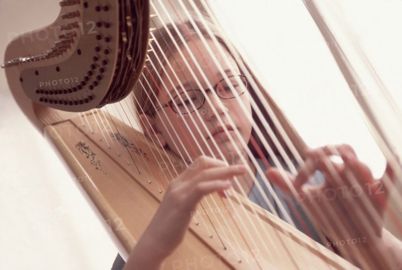 Young girl playing the harp. Photographe : Rob Lewine
