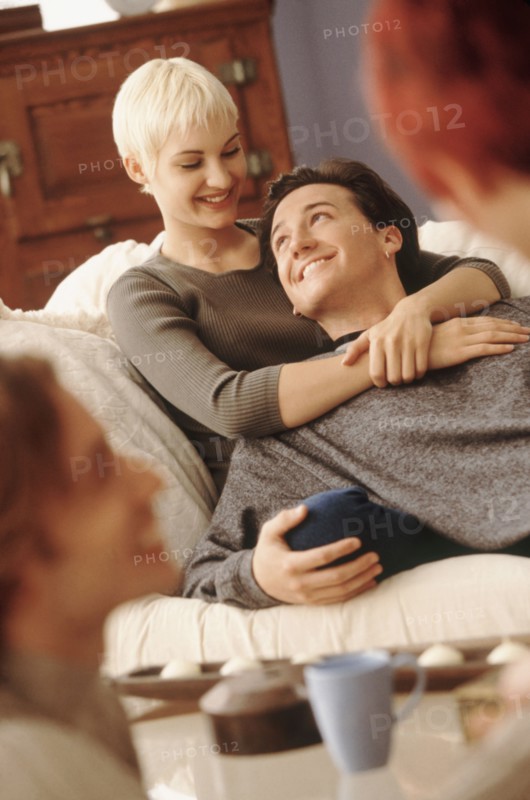 Couple relaxing on couch together. Photographe : Rob Lewine