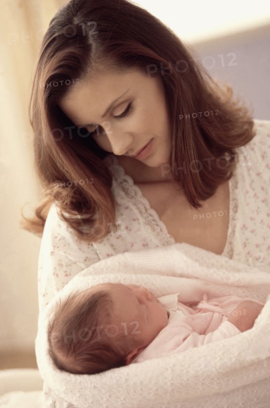 Mother holding her newborn baby. Photographe : Rob Lewine