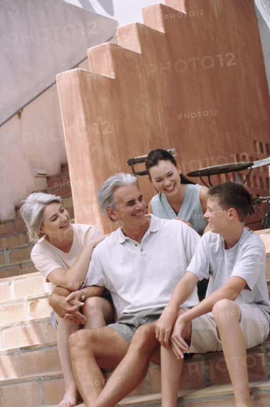 Family sitting on steps together. Photographe : Rob Lewine