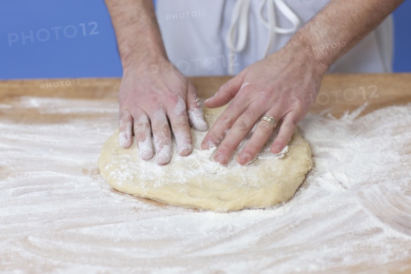 Man's hands kneading bread dough. Photographe : Dan Bannister