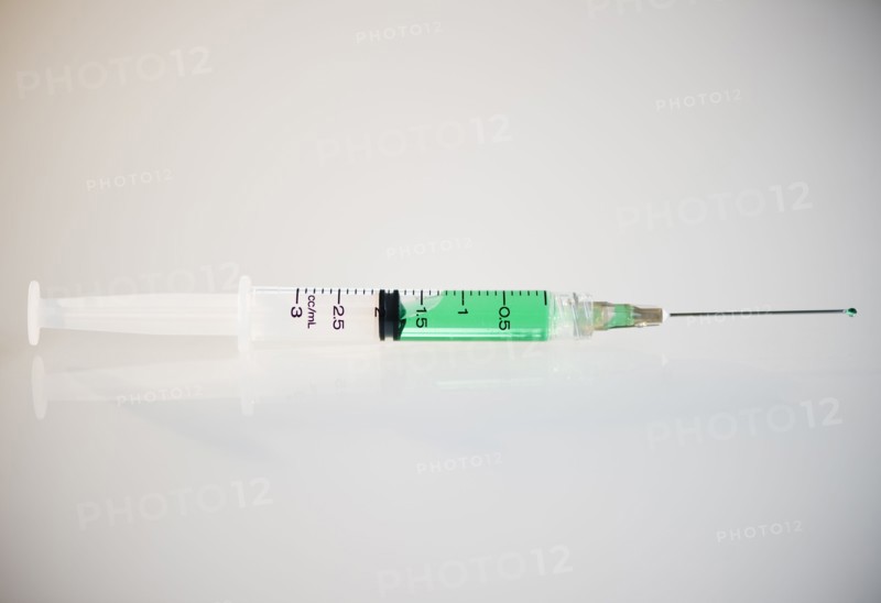 Syringe filled with green liquid. Photo : Jamie Grill