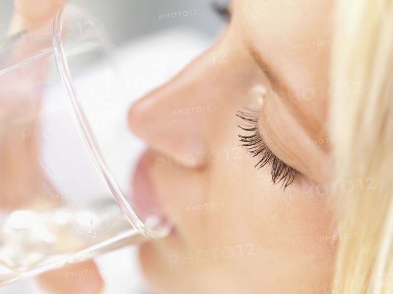 Woman drinking a glass of water. Photo : momentimages