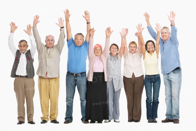 A group of people standing in a row raising their arms. Photo : momentimages