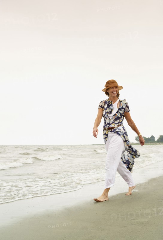 Woman walking on the beach. Photo : Shawn O'Connor