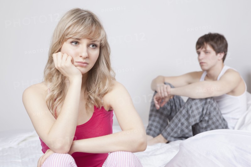 Couple sitting on bed after arguing. Photo : Take A Pix Media