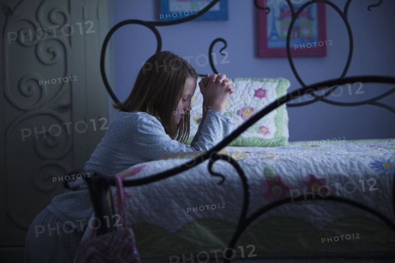 Young girl praying before bed. Photo : Mike Kemp