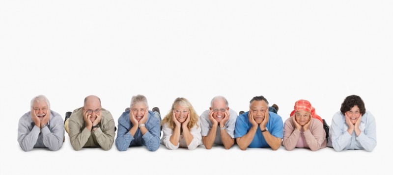 A group of people lying on the floor in a row. Photo : momentimages