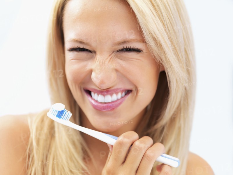 Woman about to brush her teeth. Photo : momentimages