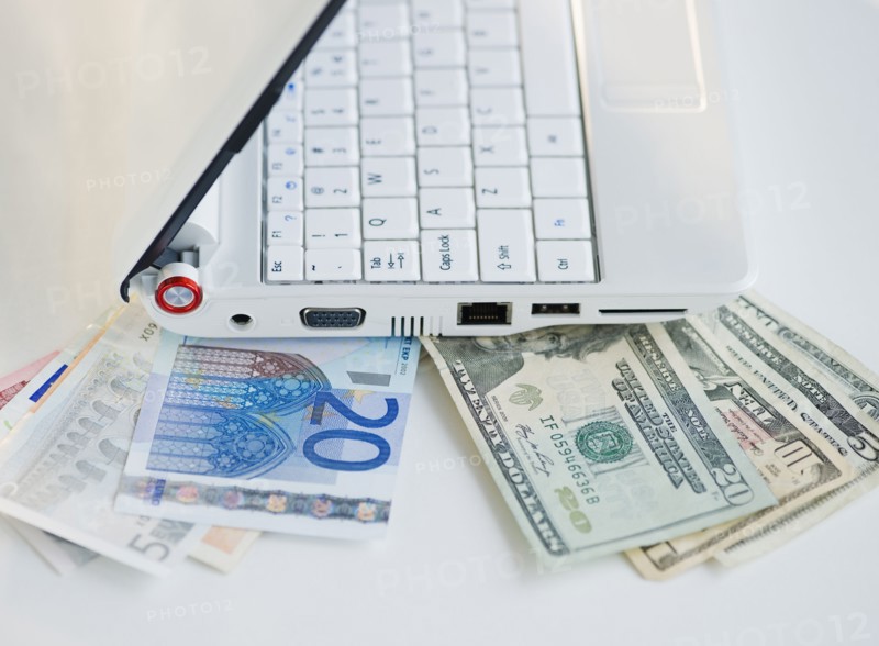 Money tucked underneath laptop. Photo : Jamie Grill