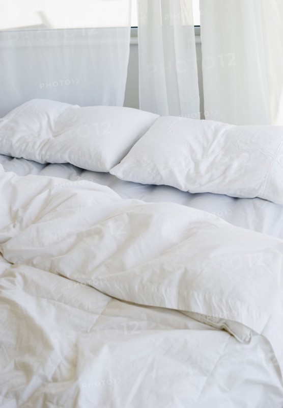 Bed with white linens.