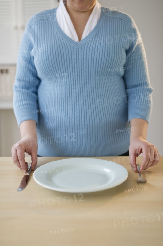 Overweight woman setting the table.