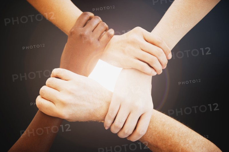 Four hands holding wrists of other people.