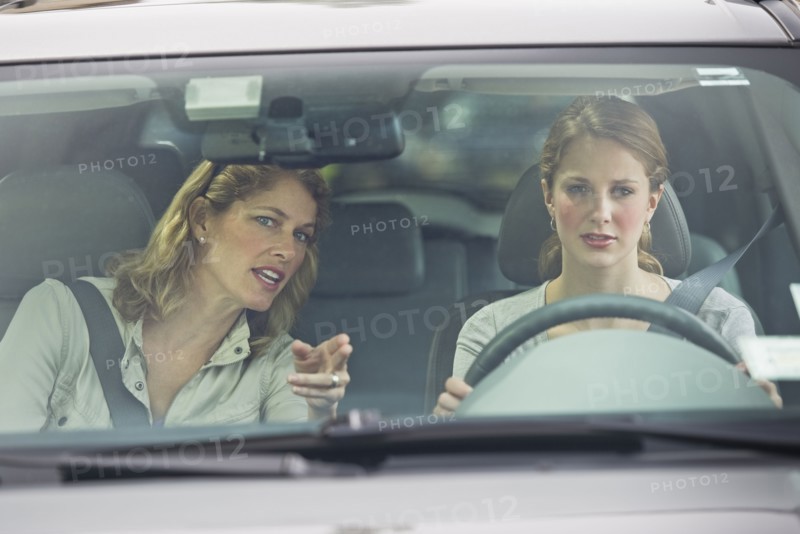 Mother teaching her daughter how to drive.