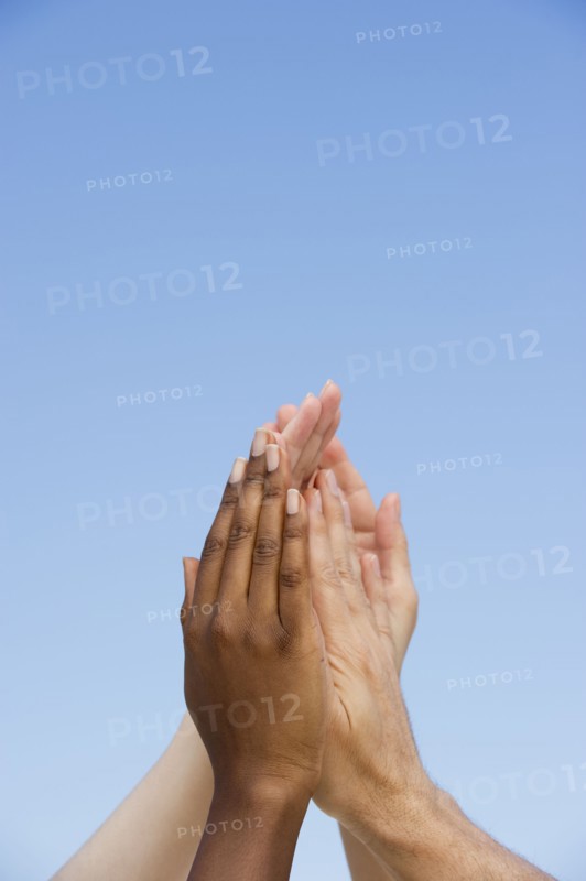 Four hands reaching up.