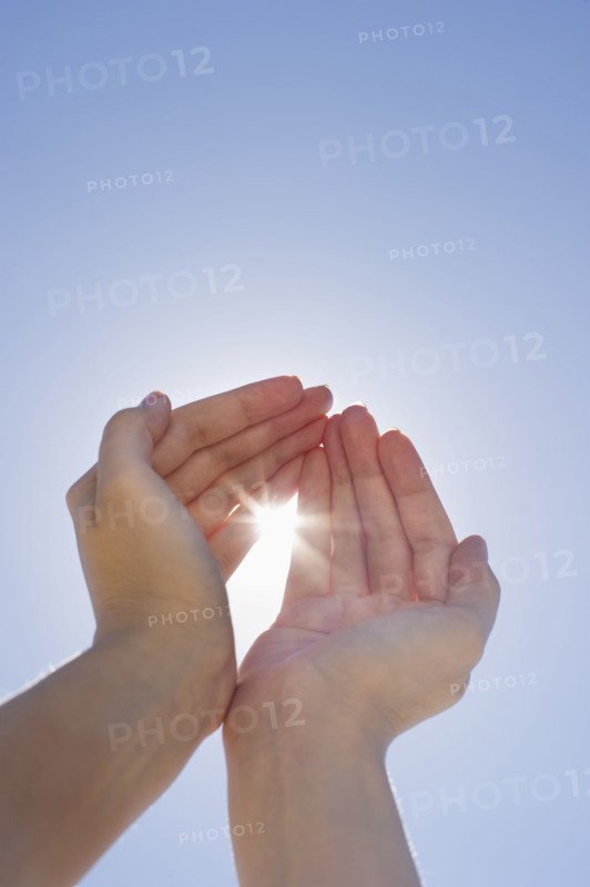 Hands framing sunshine.