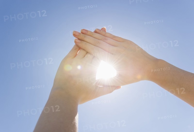 Hands framing sunshine.