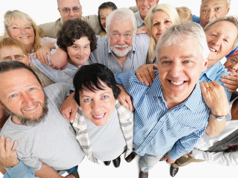 A group of people standing with their arms around each other. Photo : momentimages