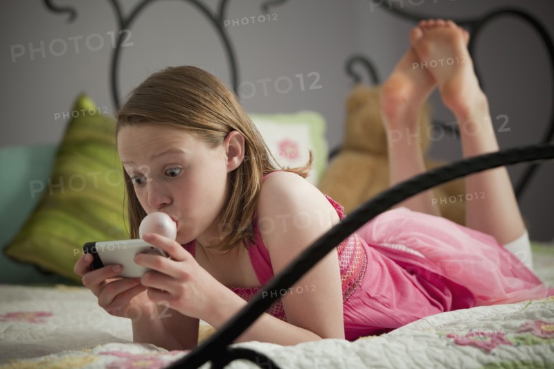 Surprised young girl reading text. Photo : Mike Kemp