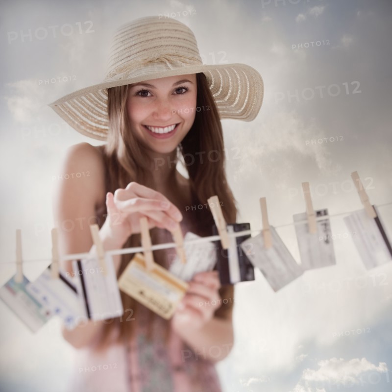 Woman hanging credit cards on clothesline. Photo : Mike Kemp