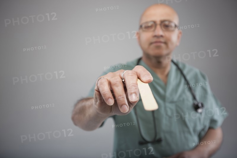 Doctor holding a tongue depressor. Photo : Dan Bannister
