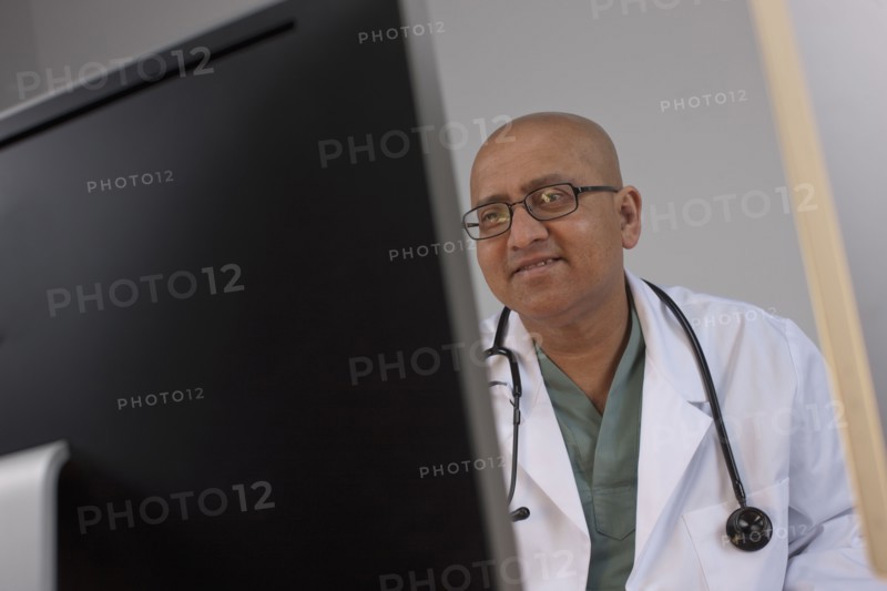 Doctor looking at computer monitor. Photo : Dan Bannister