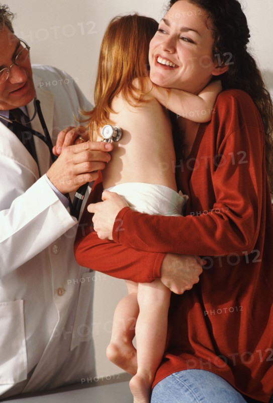 Toddler hugging her mother during medical check-up. Photo : Rob Lewine