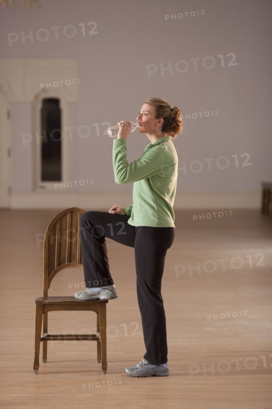 Woman drinking water after exercising. Photo : Dan Bannister