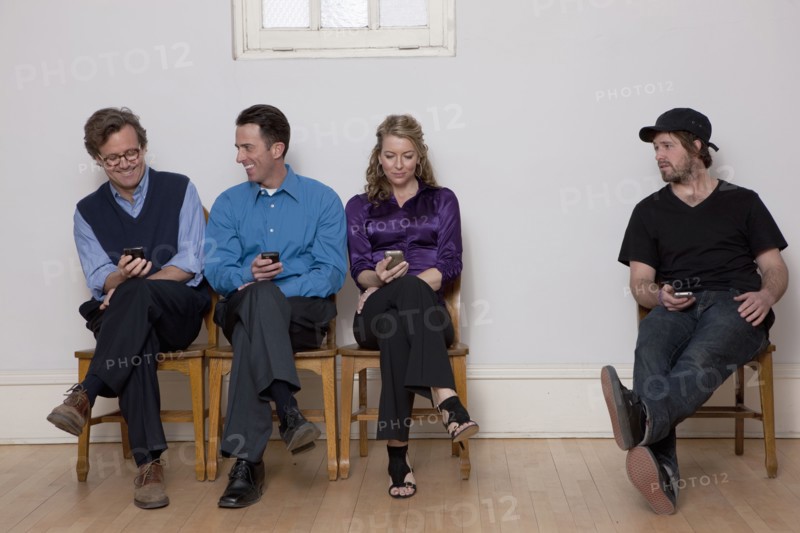 People sitting in row while holding cell phones. Photo : Dan Bannister