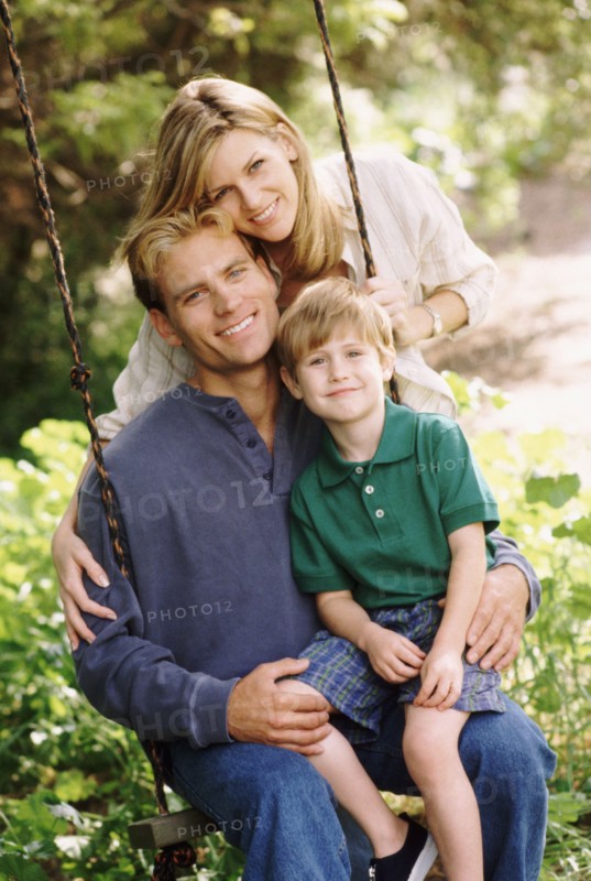 Parents and their young son posing by swing. Photo : Rob Lewine
