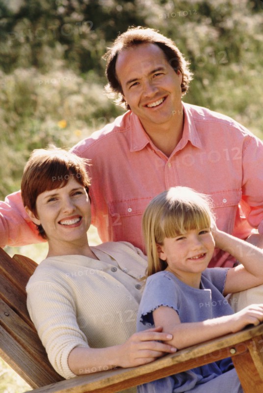 Parents and their young daughter sitting in Adirondack chair. Photo : Rob Lewine