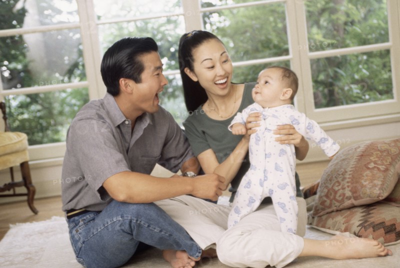 Happy parents sitting with their infant son. Photo : Rob Lewine