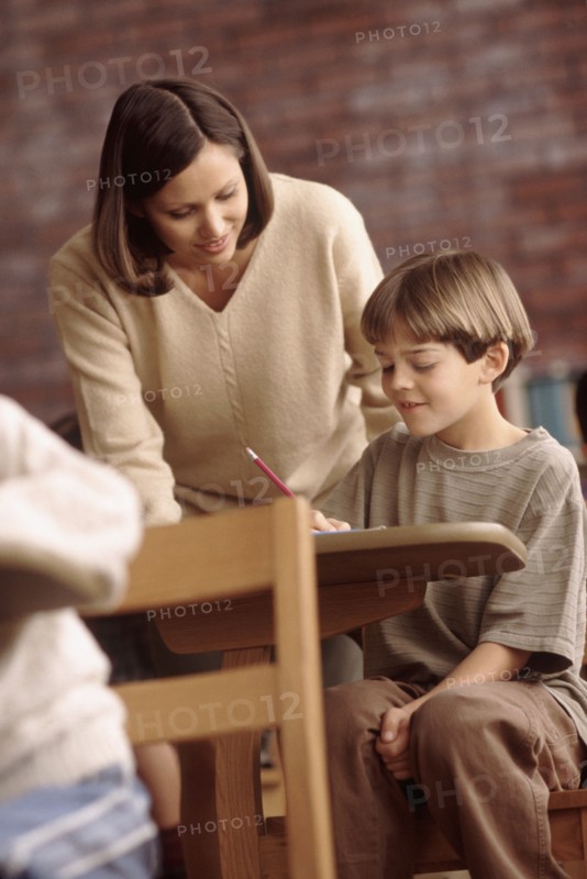 Teacher talking to elementary school student. Photo : Rob Lewine