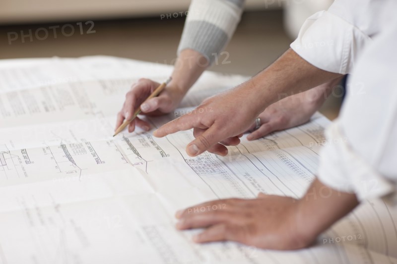 Hands pointing to a engineer's drawing. Photo : Dan Bannister